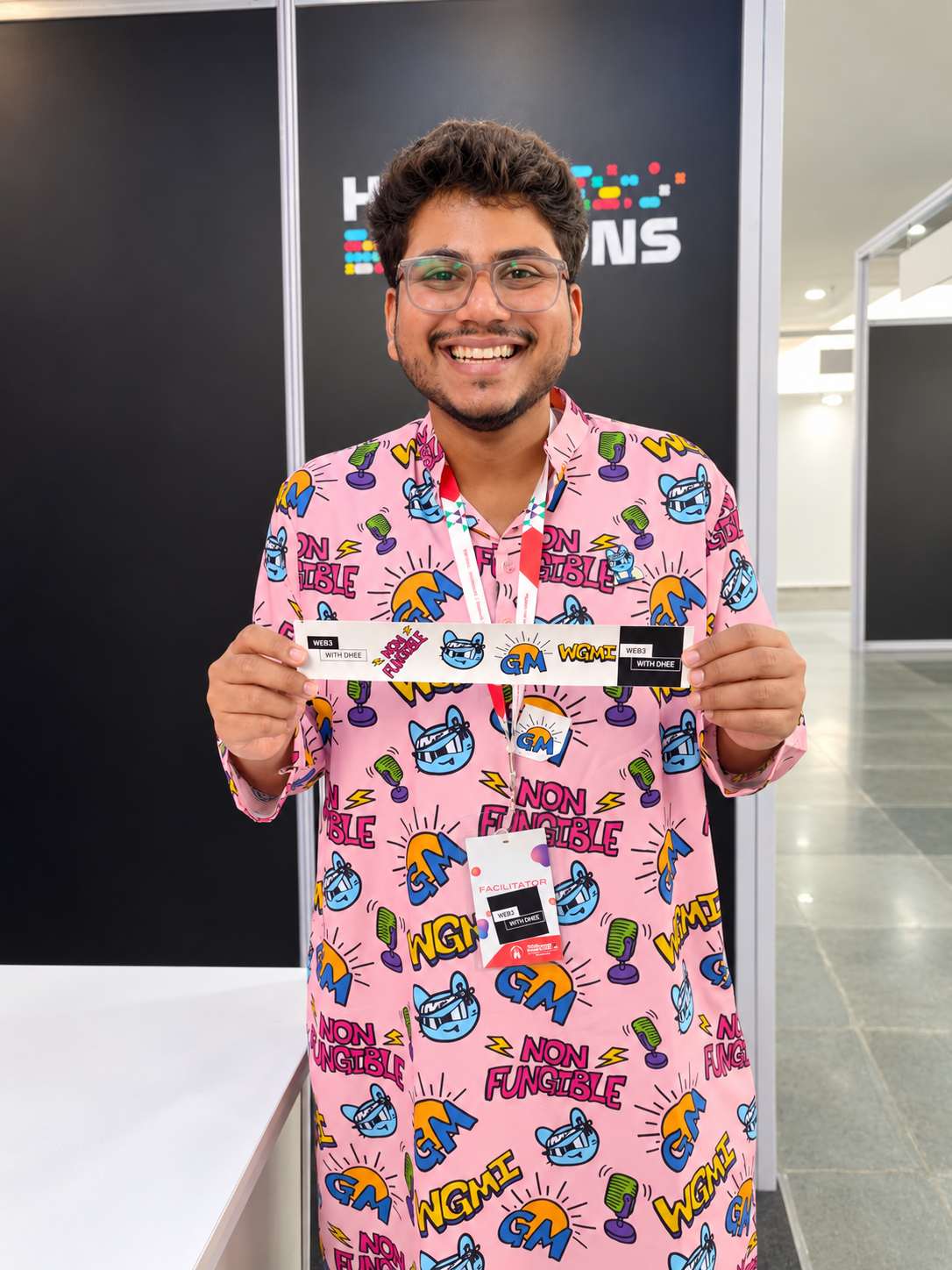 Dheeraj Shah smiling at a Web3 event in a pink Web3 With Dhee shirt